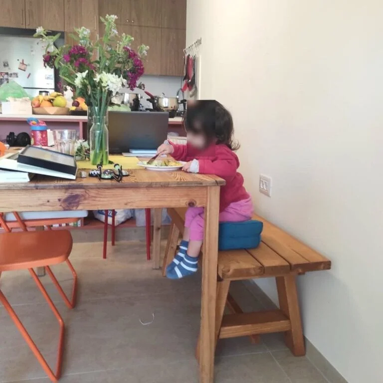 ספסל עץ ללא משענת דגם "טל" ליד שולחן אוכל, ילדה יושבת עליו