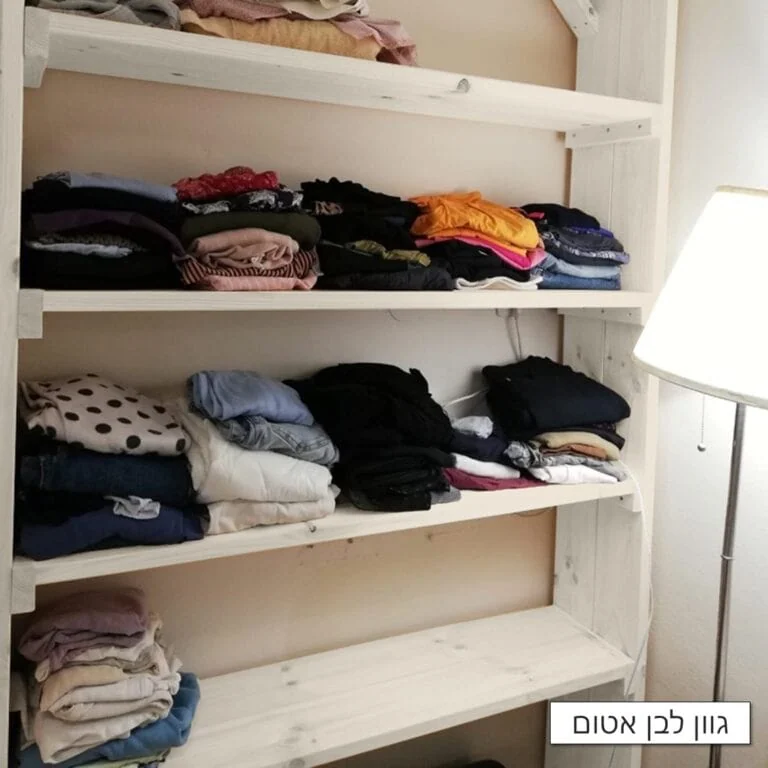 כוננית מדפים גדולה דגם שחר בגוון לבן אטום עמוסה בבגדים מקופלים