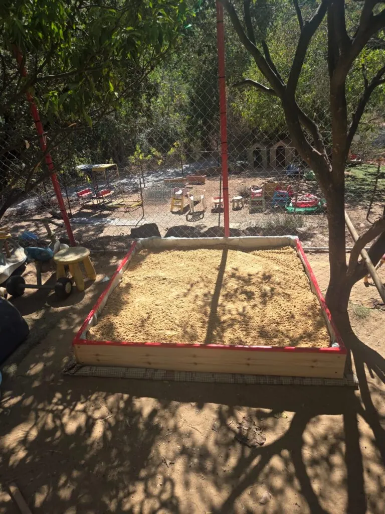 ארגז חול לילדים מעץ דגם אביעד מלא חול בגינה תחת עץ