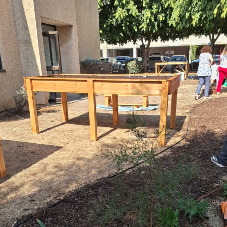 ערוגה מוגבהת מעץ דגם "ניצן" מוצבת בגינה על קרקע מיושרת